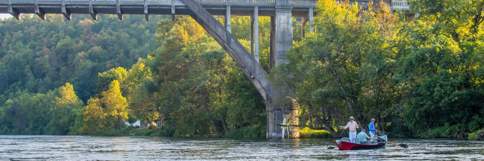 Fly fishermen in a drift boat on the White River near Cotter, Arkansas, under the Cotter bridge